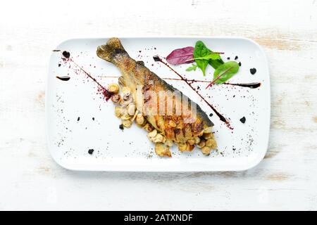 Trota alla griglia con funghi su un piatto. Vista dall'alto. Spazio libero di copia. Foto Stock