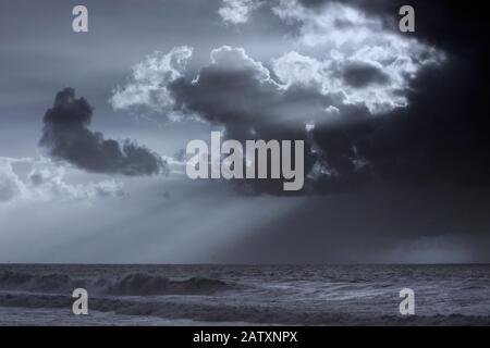 Drammatico cielo nuvoloso con raggi solari. Filtro a infrarossi utilizzato. Blu tonato. Foto Stock