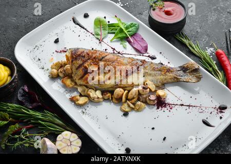 Trota alla griglia con funghi su un piatto. Vista dall'alto. Spazio libero di copia. Foto Stock