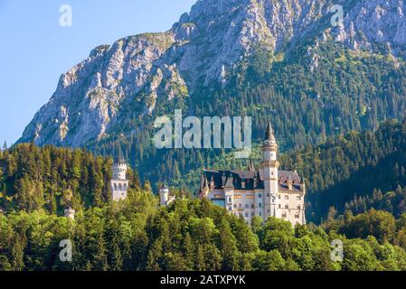 Castello di Neuschwanstein in montagna, Baviera, Germania. E' un famoso punto di riferimento delle Alpi tedesche. Paesaggio con foresta e castello di Neuschwanstein in summe Foto Stock