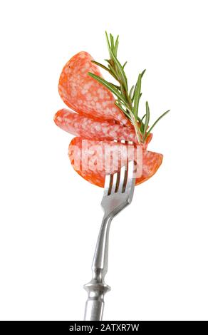 Fettine di salame ungherese e rosmarino fresco su forchetta isolato su bianco Foto Stock