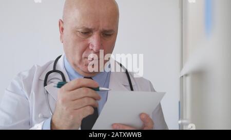 Immagine con un medico in ospedale Che Scrive su una cartella clinica informazioni paziente Foto Stock