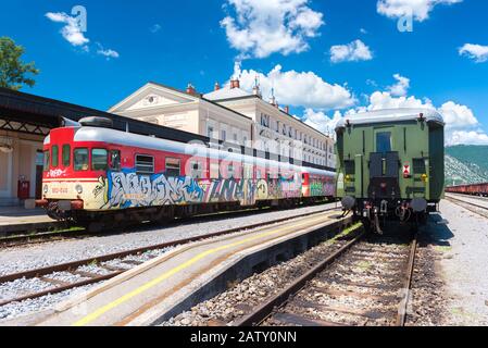 Nova Gorica (Gorizia) - Giugno 2016, Slovenia: Vista di due treni in piedi su rotaie presso la vecchia stazione ferroviaria in una soleggiata giornata estiva, prospettiva grandangolare Foto Stock