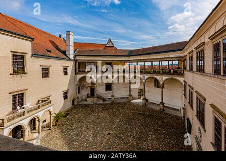 Telc / Repubblica Ceca - 27 settembre 2019: Vista su un cortile castello con portici e pavimentazione in ciottoli. Sole autunno giorno con cielo blu e nuvole. Foto Stock
