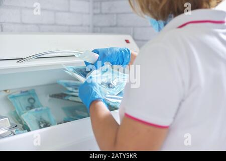 Infermiere femmina che esegue la sterilizzazione di strumenti medici dentali in autoclave. Reparto di sterilizzazione presso la clinica odontoiatrica Foto Stock