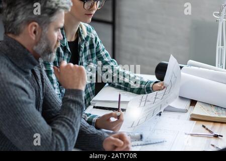 I progettisti di interni lavorano in ufficio con progetti e attrezzature per architetti, schizzi, progetti di negoziazione e pianificazione della costruzione. Partner Foto Stock