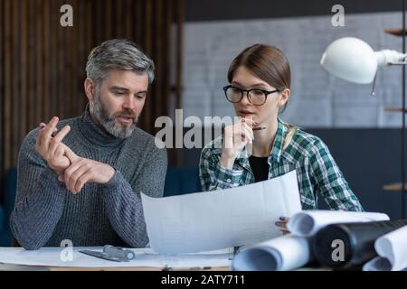 I progettisti di interni lavorano in ufficio con progetti e attrezzature per architetti, schizzi, progetti di negoziazione e pianificazione della costruzione. Partner Foto Stock