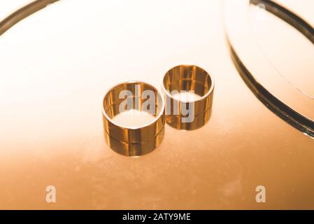 Anelli da sposa su uno stand in tonalità oro. Foto Stock