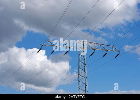 Linea di trasmissione di potenza contro cielo con nuvole Foto Stock