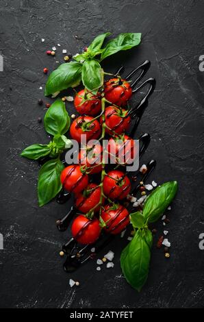 Pomodori ciliegini freschi su sfondo nero. Vista dall'alto. Spazio libero per il testo. Foto Stock