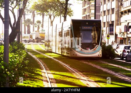 Izmir, Turchia - 23 settembre 2018: Tram di Izmir su rotaie tra gli alberi e erba verde a Cankaya Izmir. Foto Stock