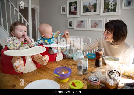 gemelle di 6 mesi in bumbo che vengono svezzate Foto Stock