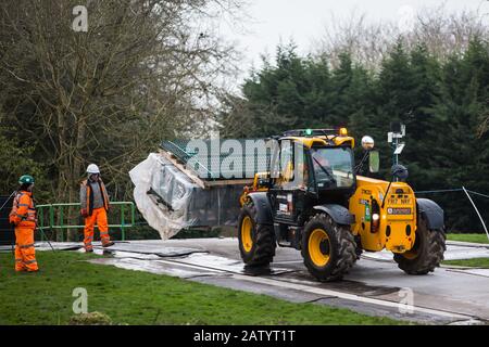 Denham, Regno Unito. 5 Febbraio 2020. Un veicolo carrello elevatore JCB trasporta scherma attraverso una strada temporanea al Buckinghamshire Golf Club nella Valle di Colne per lavori progettati in combinazione con il collegamento ferroviario ad alta velocità HS2, tra cui la abbattimento di alberi antichi in una riserva naturale sull'altro lato del fiume Colne e la costruzione Di un ponte Bailey attraverso il fiume. Gli attivisti ambientali occupano alberi nel Denham Country Park nel tentativo di impedire o ostacolare il lavoro. Credit: Mark Kerrison/Alamy Live News Foto Stock