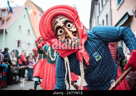 La strega Kandel di Waldkirch, bella strega in un abito blu e rosso sembra sorpreso dal lato durante la sfilata di carnevale a Staufen, Germ meridionale Foto Stock