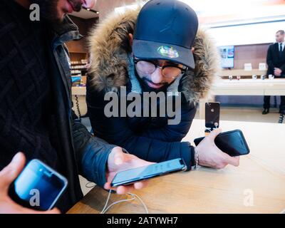 Parigi, Francia - 3 novembre 2017: Curiosi clienti maschi ammirando all'interno dell'Apple Store il più recente smartphone professionale iPhone 11 pro prodotto da Apple Computers Foto Stock