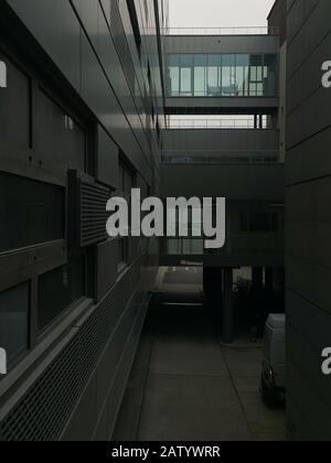 Vista sopraelevata del moderno edificio ospedaliero con passarela tra l'edificio e il reparto ospedaliero vuoto nel mezzo Foto Stock