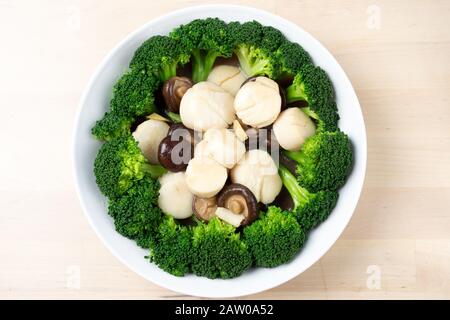Mescolare le capesante fresche fritte con broccoli e funghi Foto Stock