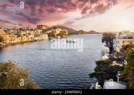 Lago Pichola con City Palace magica vista al tramonto cielo a Udaipur, Rajasthan, India Foto Stock