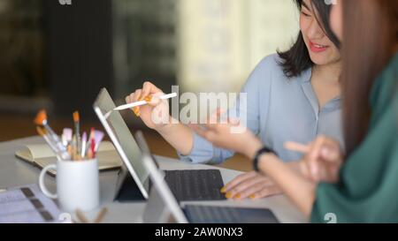 Un taglio corto di team di designer professionisti che si consultano sul loro progetto nella moderna sala riunioni Foto Stock