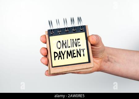 Pagamento Online. Concetto Di Acquisto, Vendita, Trasferimenti E Transazioni Finanziarie. Nota libro in mano su sfondo bianco Foto Stock
