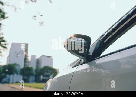 Vista dal lato posteriore della nuova vettura bianca il parcheggio sulla strada asfaltata in tempo al tramonto Foto Stock