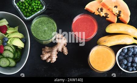 Diversi tipi di frullati su sfondo nero. Sano pulito e concetto di dieta detox. Vista dall'alto Foto Stock