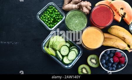 Diversi tipi di frullati su sfondo nero. Sano pulito e concetto di dieta detox. Vista dall'alto con spazio di copia Foto Stock