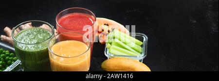 Diversi tipi di frullati su sfondo nero. Sano pulito e concetto di dieta detox. Panorama, banner con spazio di copia Foto Stock