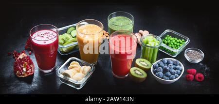 Diversi tipi di frullati su sfondo nero. Sano pulito e concetto di dieta detox. Panorama, banner Foto Stock