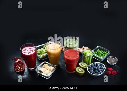 Diversi tipi di frullati su sfondo nero. Sano pulito e concetto di dieta detox. Immagine con spazio di copia Foto Stock