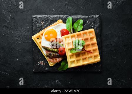 Colazione. Waffle belgi con uova, asparagi e pancetta. Cibo sano. Vista dall'alto. Spazio libero per il testo. Foto Stock