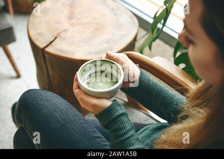 Ragazza aromatico bevande salutari e freschi Verde matcha latte tè in una caffetteria. Foto Stock