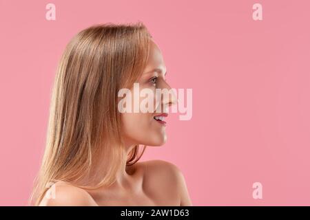 Bella signora senza trucco e con pelle sana e denti bianchi che si posano nel profilo Foto Stock