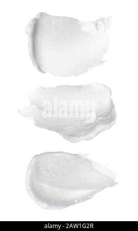 White cospargere di crema cosmetica o bianco vernice acrilica isolati su sfondo bianco. Foto Stock