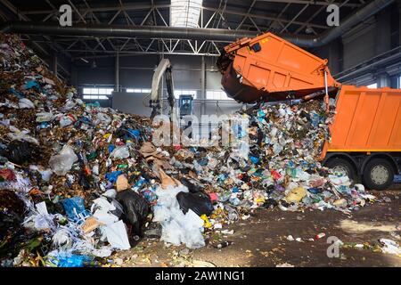 GRODNO, Bielorussia - Ottobre 2018: impianto di riciclaggio del processo di scarico di rifiuti dai camion della spazzatura. Carichi di manipolatore garbage sul trasportatore per ulteriori pro Foto Stock