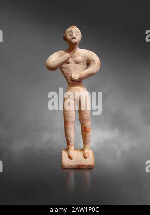 Figurina maschile in argilla minoica nell'atteggiamento di culto, Chamezi 1900-1700 a.C.; Museo Archeologico di Heraklion, sfondo grigio. Foto Stock