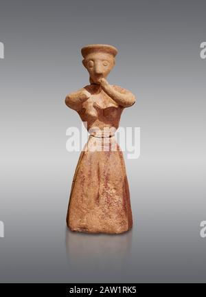 Figurina minoica femminile in argilla nell'atteggiamento di culto, Chamezi 1900-1700 a.C.; Museo Archeologico di Heraklion, sfondo grigio. Foto Stock