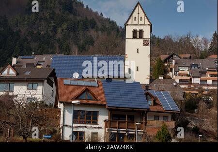 I collettori solari sui tetti e il tetto della chiesa nella comunità della Foresta Nera di Schönau Germania vicino a Titisee generano una gran parte dei bisogni energetici della comunità. Foto Stock