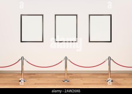 Tre cornici vuote in fila su una parete color crema in una galleria d'arte con corda di barriera e pali Foto Stock