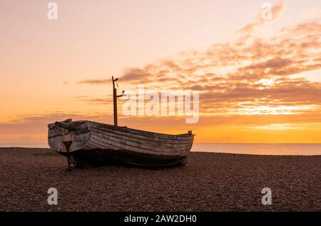 Imbarcazione da pesca abbandonata sulla spiaggia di Aldeburgh all'alba. Aldeburgh Suffolk Regno Unito. Foto Stock