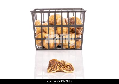 Gruppo di lotti interi due metà di fico secco in cestello di plastica nero isolato su fondo bianco Foto Stock