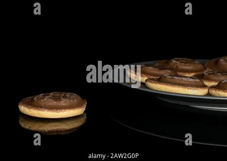 Lotto di biscotto al cioccolato intero su lastra di ceramica grigia isolata su vetro nero Foto Stock