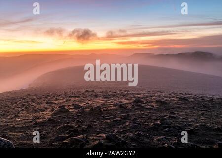 The View South at Dawn from the Summit Shelter on Helvellyn as Mist Che Si Trova Sull'altopiano, Lake District, Cumbria, Regno Unito Foto Stock