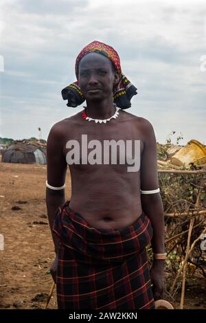 Omorate, Etiopia - Nov 2018: Dasanech uomo della tribù con tagli nel suo corpo orgogliosamente in piedi. Valle di Omo Foto Stock