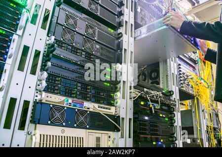 Sostituzione di apparecchiature di emergenza nel rack del server. Lavorare con i server del data center. Foto Stock