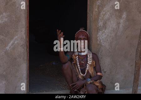 Turmi, Etiopia - Nov 2018: Signora della tribù Hamer seduto di fronte alla casa. Valle di Omo Foto Stock