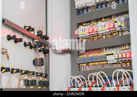 Una scatola fusibili aperta si trova sulla parete nel seminterrato. Quadro di comando elettrico ad alta tensione. Scatola Elettrica In Ferro Foto Stock