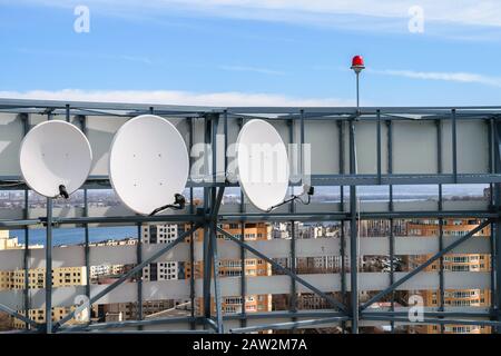 Sul tetto dell'edificio sono installate tre antenne satellitari. Foto Stock