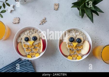 La colazione dei bambini è divertente e i porridge sembrano dei simpatici gufi Foto Stock