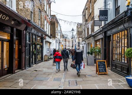 Gli amanti dello shopping curiosano tra i negozi di antiquariato e le bancarelle di Camden Passage all'Angel, Islington, Londra, Regno Unito Foto Stock